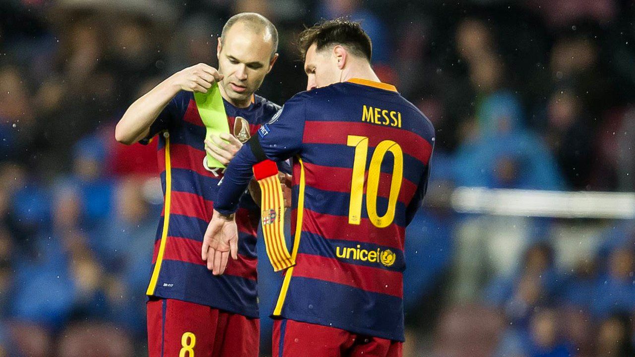 Andrés Iniesta cediéndole la cinta de capitán a Lionel Messi<br>