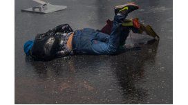 Un joven caído en el asfalto durante las protestas en Venezuela Un joven caído en el asfalto durante las protestas en Venezuela