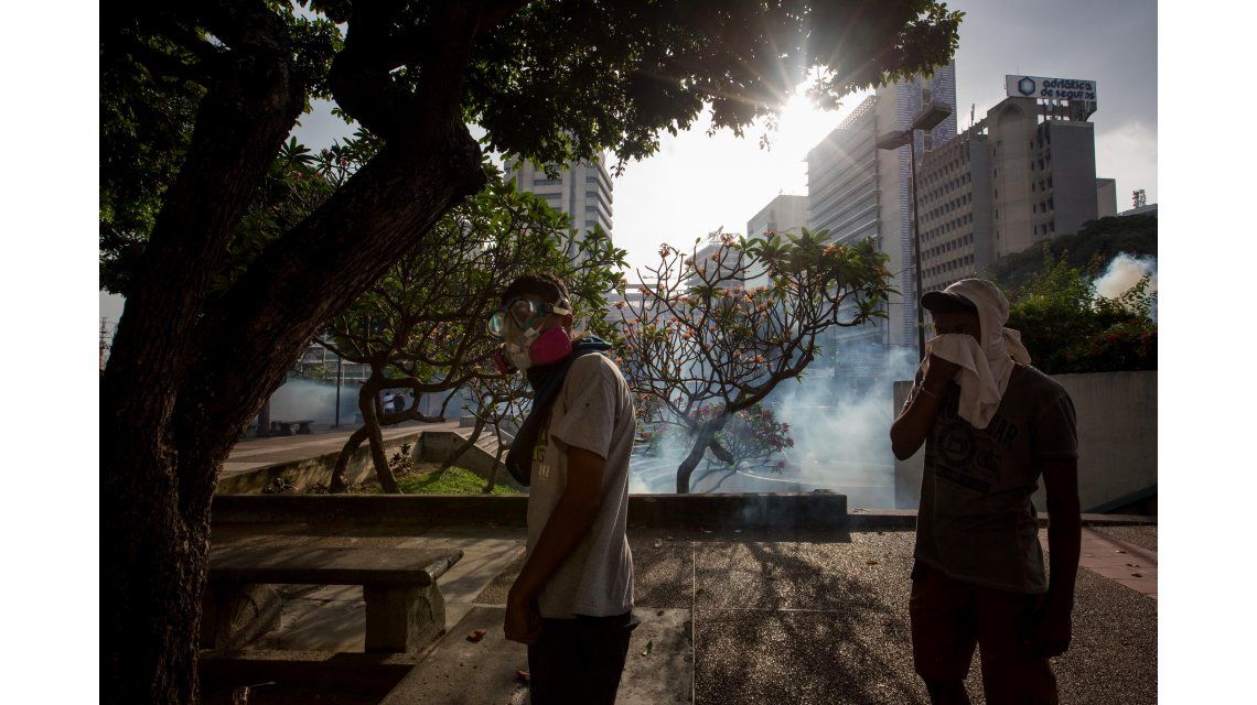 Jóvenes se protegen de los gases lacrimógenos Jóvenes se protegen de los gases lacrimógenos