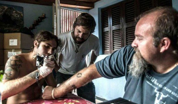 Santiago le hace un tatuaje a Sergio. Con Germán, el otro hermano, de testigo