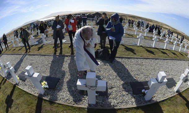Un sacerdote bendice una de las tumbas<br>
