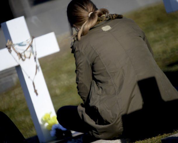 Una de las familiares acompaña la cruz blanca que identifica a su héroe<br>