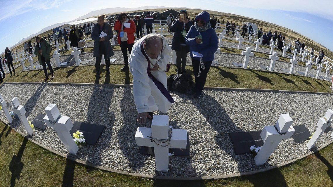 Un sacerdote bendice una de las tumbas Un sacerdote bendice una de las tumbas