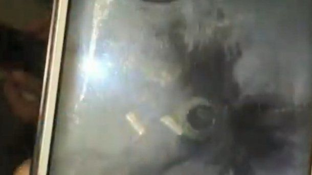 Un celular muestra la imagen del avión impactado por un rayo.