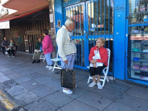Una jubilada aguarda sentada su turno