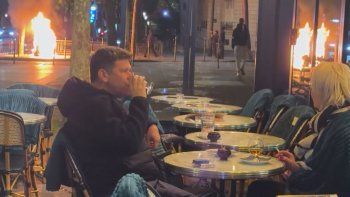 una pareja de parisinos distendidos en un bar en medio del fuego y los disturbios que sacuden francia una pareja de parisinos distendidos en un bar en medio del fuego y los disturbios que sacuden francia