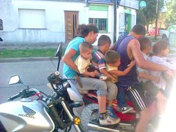 siete personas hacen equilibrio sobre una moto siete personas hacen equilibrio sobre una moto