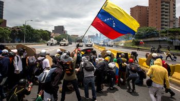 Opositores alzan una bandera de Venezuela Opositores alzan una bandera de Venezuela