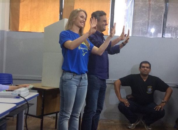 El candidato opositor Neves votó y saludó con el gesto de la victoria