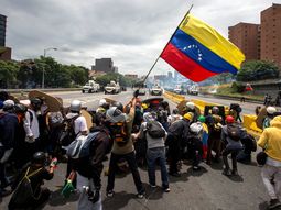 Opositores alzan una bandera de Venezuela Opositores alzan una bandera de Venezuela