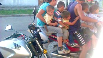 siete personas hacen equilibrio sobre una moto siete personas hacen equilibrio sobre una moto