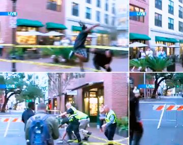 Un hombre salta una barricada para arrebatar una bandera que representa la supremacía blanca