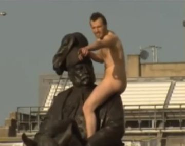 Un hombre desnudo sobre la estatua del duque de Cambridge