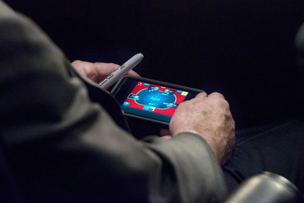 Escrachan a un senador jugando al póker en el debate por Siria