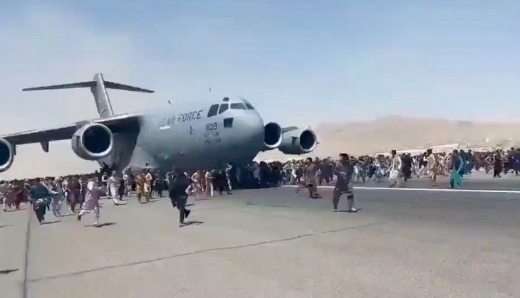 Decenas de personas corren alrededor de un avión de carga militar estadounidense que se preparaba para comenzar el despegue del aeropuerto de Kabul