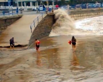 Una ola se lleva de imprevisto a una turista distraída