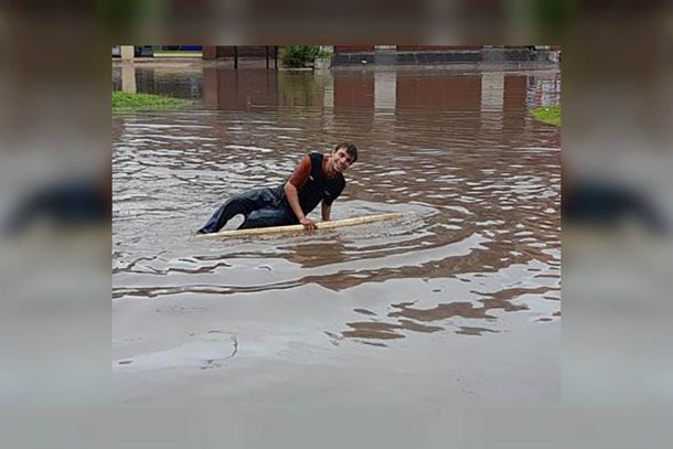 Salió a surfear en la calle inundada en medio del temporal