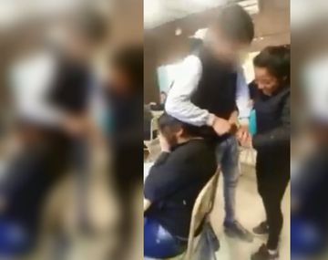 La chica se tapó la cara mientras sus compañeros le cortaban el pelo
