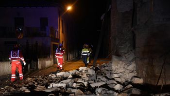 Un grupo de bomberos y rescatistas camina por los escombros Un grupo de bomberos y rescatistas camina por los escombros