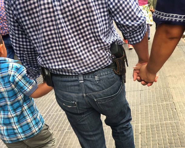 Un hombre camina armado en pleno centro de Tucumán.