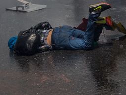 Un joven caído en el asfalto durante las protestas en Venezuela