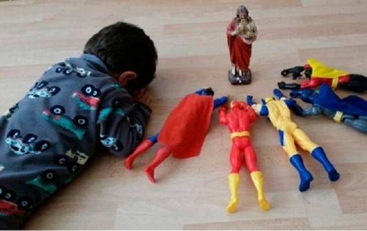 Un nene reza junto a sus superhéroes