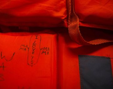 Refugiados escriben mensajes y números de contacto en chalecos salvavidas por si mueren