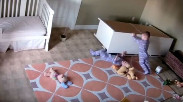 Uno de los gemelos corre el mueble para ayudar a su hermano atrapado