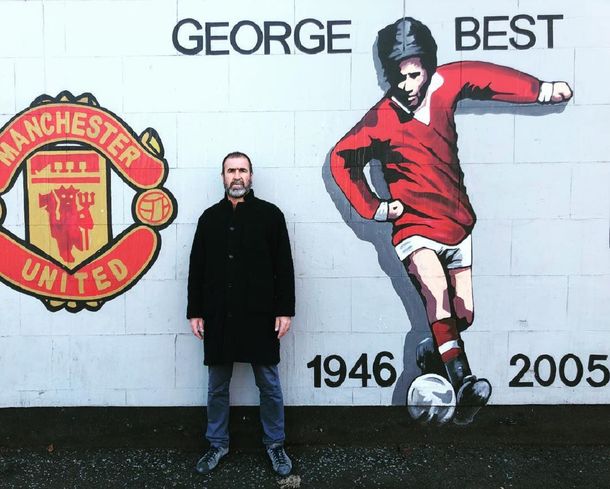 Eric Cantona junto a un mural de George Best