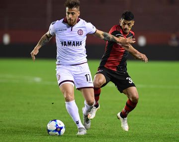 Germán Denis lleva la pelota ante su marcador
