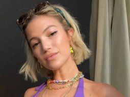 Stefi Roitman bailando sonriente con una microbikini rosada en un yate a contraluz