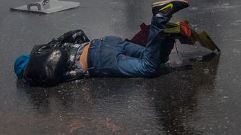 Un joven caído en el asfalto durante las protestas en Venezuela Un joven caído en el asfalto durante las protestas en Venezuela