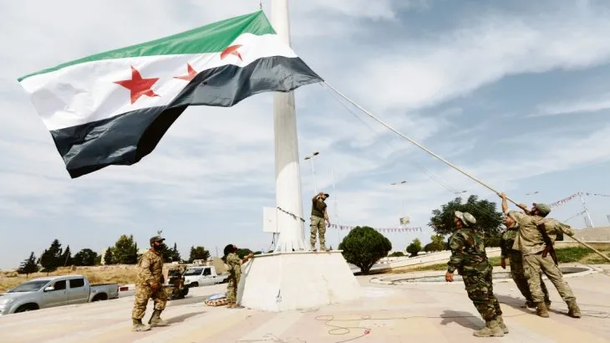 Rebeldes sirios que apoyan la ofensiva turca izan su propia bandera en Tel Abyad, hasta ayer territorio kurdo en Siria.