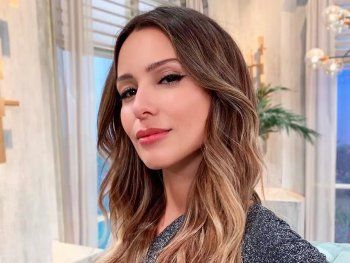 Pampita de espaldas frente a un paisaje espectacular con una microbikini bordó en Ibiza
