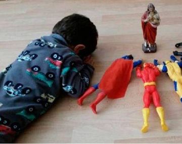 Un nene reza junto a sus superhéroes