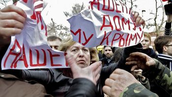 Unos hombres no identificados rompen un cartel que sostiene una manifestante, en el que se lee Paz para nuestro hogar, Crimea. Unos hombres no identificados rompen un cartel que sostiene una manifestante, en el que se lee Paz para nuestro hogar, Crimea.