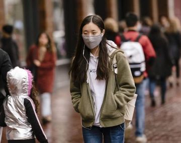 Una mujer camina con barbijo para protegerse del coronavirus Foto: América Económica