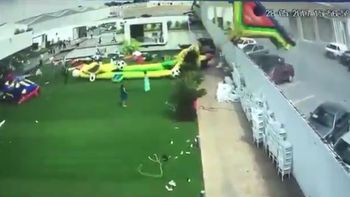 El viento levantó juegos inflables: una nena está delicada El viento levantó juegos inflables: una nena está delicada