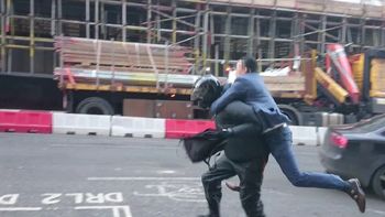 un hombre de traje detiene a un motochorro un hombre de traje detiene a un motochorro