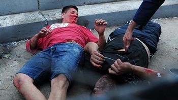 Mario Becerra, de remera roja, yace herido en el piso Mario Becerra, de remera roja, yace herido en el piso