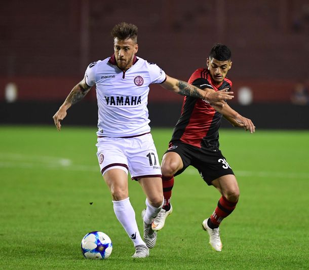 Germán Denis lleva la pelota ante su marcador