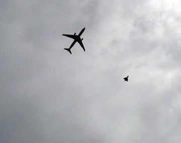 Un caza de combate escolta a un avión de pasajeros por un dispositivo sospechoso