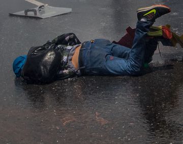 Un joven caído en el asfalto durante las protestas en Venezuela