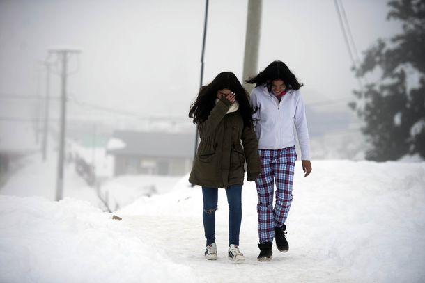 Dos chicas caminan en medio de la nieve en San Carlos de Bariloche
