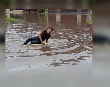 Salió a surfear en la calle inundada en medio del temporal