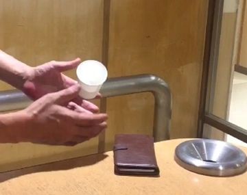 Un truco de magia donde una japonés hace levitar un vaso y un cigarrillo