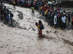Personas intentan cruzar el río La Digue, en Haití, debido al derrumbe del único puente que conecta con el sur, tras el paso del huracán Matthew. Personas intentan cruzar el río La Digue, en Haití, debido al derrumbe del único puente que conecta con el sur, tras el paso del huracán Matthew.