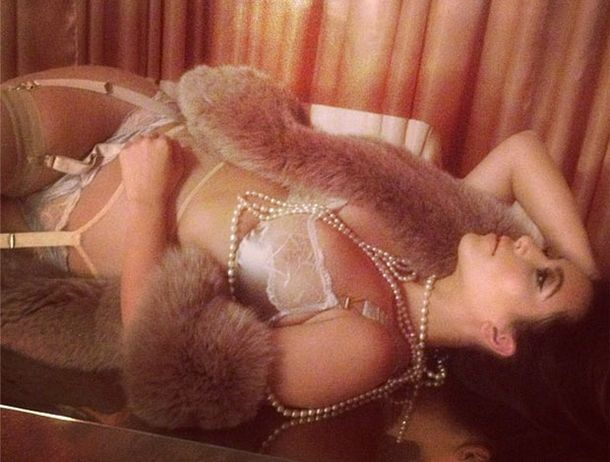 Ella duerme con pieles, perlas y encaje