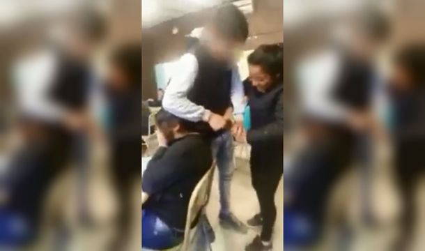 La chica se tapó la cara mientras sus compañeros le cortaban el pelo