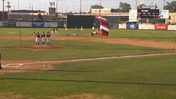 Un paracaidista aterriza sobre un jugador de béisbol